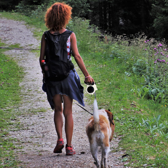 femme balade chien portant laisse enrouleur eclarée-parc